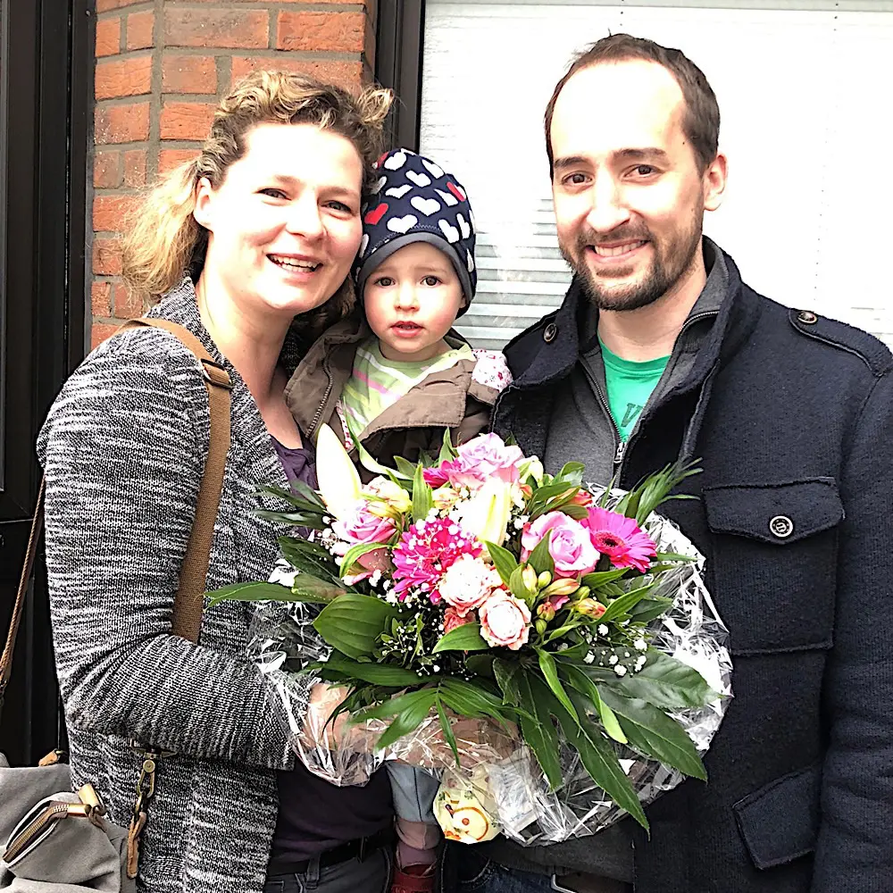 Zufriedene Immobilieneigentümer in Köln Flittard Immobilienmakler Köln nach erfolgreichem Notartermin mit überreichtem Blumenstraußer Notartermin Blumen überreicht