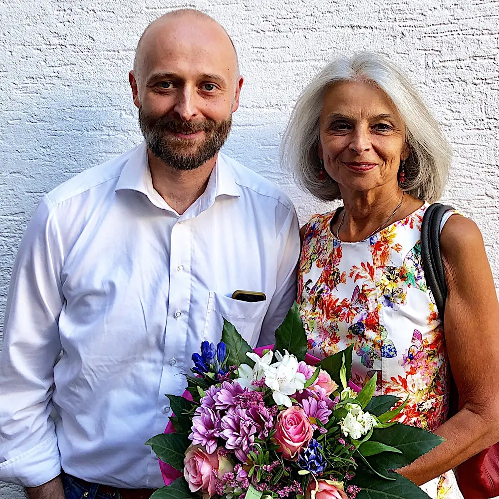 Zufriedene Immobilieneigentümer in Köln Brück Immobilienmakler Köln nach erfolgreichem Notartermin mit überreichtem Blumenstrauß