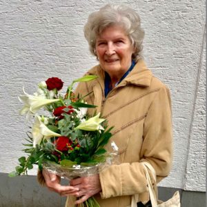 Zufriedene Immobilieneigentümer in Köln Immobilienmakler Köln nach erfolgreichem Notartermin mit überreichtem Blumenstrauß